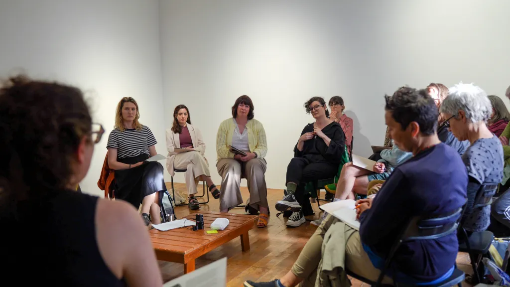 Image from the Art of Just Transition panel talk, audience and panellists in circle talking.