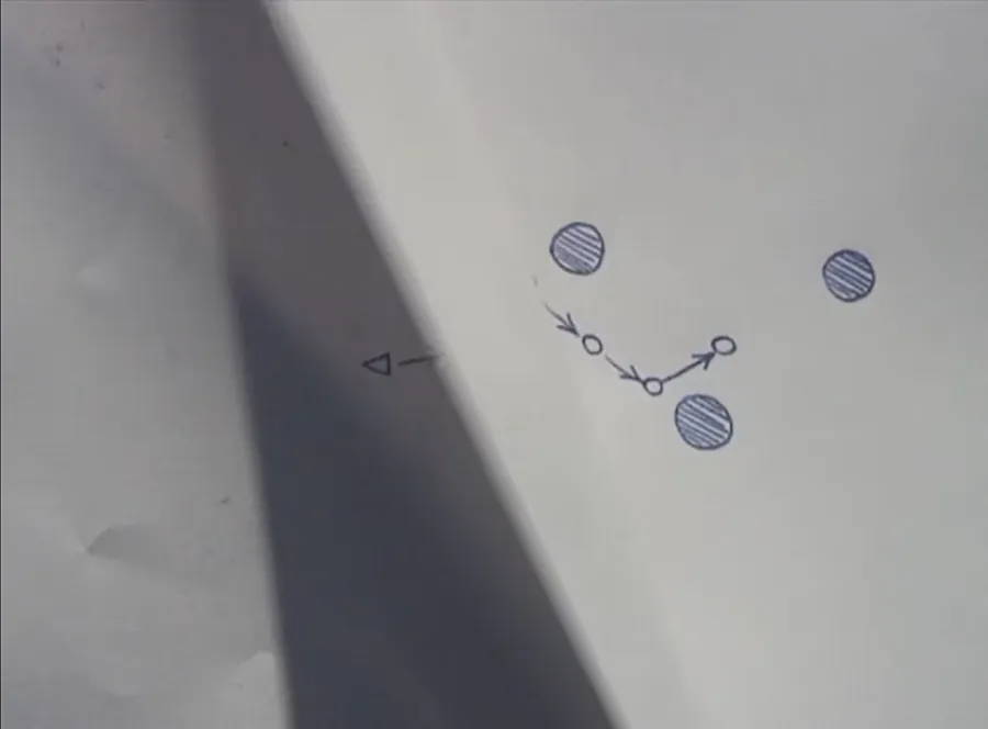 film still of white background with a blue pen diagram. 