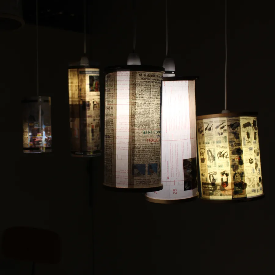 Detail of work by Cillian Finnerty. Several lamps with custom shades made from newspaper and magazine pages.