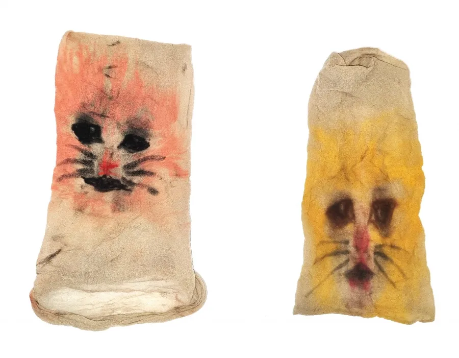 Two sheer stockings with pink and orange cat faces painted onto them, resembling makeshift masks.