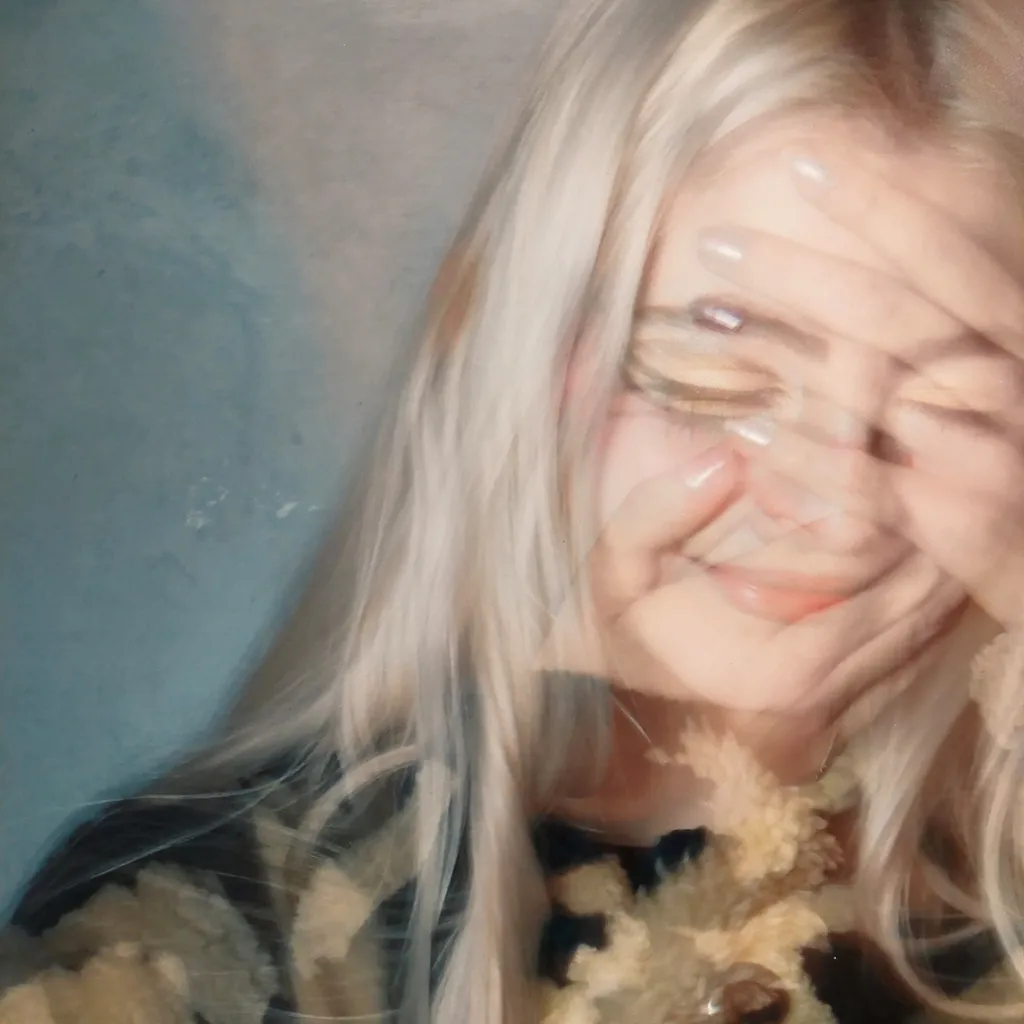 A layered image of a woman smiling with her hands on her face.