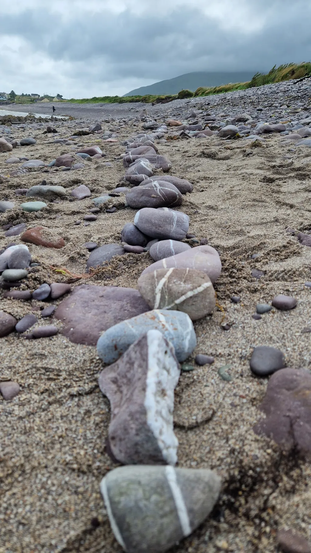 Photo of a stoney beach with a man-made trail of stones placed in a line